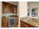 Wet bar with wine cooler and granite countertop at 9325 E Paraiso Dr, Scottsdale, AZ 85255