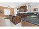 Island kitchen with granite countertops and dark wood cabinets at 7132 W Trenton Way, Florence, AZ 85132