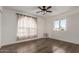 Bedroom with hardwood floors, ceiling fan and arched window at 8039 E Madero Ave, Mesa, AZ 85209