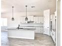 Modern kitchen with white cabinets, large island, and wood-look floors at 0000 W Hooper Trl # 2, Queen Creek, AZ 85144