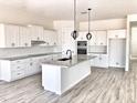Modern kitchen with white cabinets, large island, and wood-look floors at 0000 W Hooper Trl # 2, Queen Creek, AZ 85144