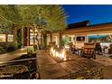 Expansive backyard with fire pit and seating area at night at 10040 E Happy Valley Rd # 1, Scottsdale, AZ 85255