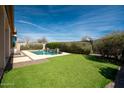 Inviting backyard oasis with a sparkling pool and lush landscaping at 21521 S 215Th Pl, Queen Creek, AZ 85142