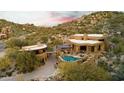 Aerial view of a luxury home with a pool and stunning desert mountain views at 11225 E Whispering Ridge Way, Scottsdale, AZ 85255