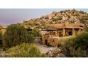 Luxury home with stone exterior and mountain backdrop at 11225 E Whispering Ridge Way, Scottsdale, AZ 85255