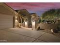 Front view of a house with a gated entry at night at 6990 E Buckhorn Trl, Scottsdale, AZ 85266