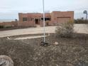 Front view of a stucco home with a flagpole and basketball hoop at 25645 W Blue Sky Dr, Wittmann, AZ 85361