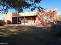 Back of the house with covered patio and grassy backyard at 25645 W Blue Sky Dr, Wittmann, AZ 85361