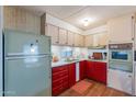 Retro kitchen with red cabinets, green refrigerator, and built-in oven at 8421 E Main St # 106, Mesa, AZ 85207