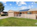Front exterior view showcasing a house with solar panels and a yard at 10712 W Cameo Dr, Sun City, AZ 85351