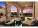 Covered patio with comfortable seating overlooking pool and sunset at 10629 E Troon North Dr, Scottsdale, AZ 85262