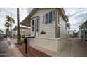 Mobile home with covered porch, and desert landscaping at 412 Hawks Eye Dr, Apache Junction, AZ 85119