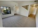 Bright and spacious living room with carpet flooring and a staircase at 17623 W Watson Ln, Surprise, AZ 85388