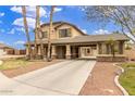 Two-story house with a covered porch and landscaped yard at 12524 W Rancho Ct, Litchfield Park, AZ 85340