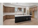 Contemporary kitchen with an island, stainless steel appliances and light wood cabinets at 17448 W Carlisle Dr, Surprise, AZ 85388