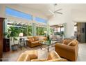 Sun-drenched living room showcasing leather furniture and backyard access at 18059 W Hickcox Dr, Surprise, AZ 85374