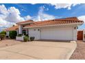 Single-story house with a two-car garage and desert landscaping at 8351 E Monte Ave, Mesa, AZ 85209