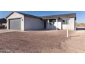 Front exterior showcasing the driveway, attached garage, and a partially landscaped yard at 4030 N Palm Cir, Eloy, AZ 85131