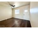 Living area with dark wood-like flooring, ceiling fan, and a door leading to the exterior at 4030 N Palm Cir, Eloy, AZ 85131