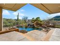 Inviting kidney-shaped pool with a waterfall feature and mountain views at 9917 E Filaree Ln, Scottsdale, AZ 85262