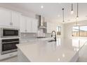 Modern kitchen with white cabinets, stainless steel appliances, and a large island at 24030 N 171St Dr, Surprise, AZ 85387