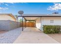 View of the home's side showcasing the carport and landscaping at 2033 W Sunnyside Ave, Phoenix, AZ 85029