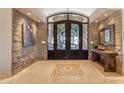 Elegant entryway with stone walls, a large double door, and tile flooring at 36202 N 36Th St, Cave Creek, AZ 85331