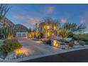 Desert landscape with house exterior at dusk at 10751 E Candlewood Dr, Scottsdale, AZ 85255