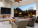Living room with fireplace and sliding doors leading to backyard and mountain views at 6296 N Lost Dutchman Dr, Paradise Valley, AZ 85253