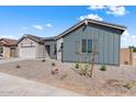 New construction home with gray siding, white garage door, and drought-tolerant landscaping at 37520 W Padilla St, Maricopa, AZ 85138