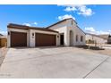 Modern stucco home with a three-car garage and desert landscaping at 37645 W Padilla St, Maricopa, AZ 85138