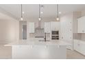 Modern kitchen island with white cabinets and quartz countertop at 20230 W Hollyhock St, Buckeye, AZ 85396