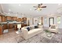Open living room with beige sofa and view into the kitchen at 25843 W Northern Lights Way, Buckeye, AZ 85326