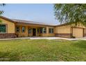 Single story house with three car garage and landscaped lawn at 25843 W Northern Lights Way, Buckeye, AZ 85326