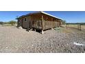 Home's side view showcasing a deck and mountainous backdrop at 7801 S 547Th Ave, Tonopah, AZ 85354