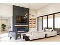 Spacious living room featuring a modern fireplace, built-in shelving, and large windows at 0 N Marchant Trace --, Queen Creek, AZ 85144