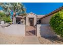 Front entrance with a decorative gate and mature palm tree at 20419 N Shadow Mountain Dr, Surprise, AZ 85374