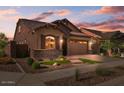 House exterior at dusk with landscaping and garage at 23148 E Carriage Way, Queen Creek, AZ 85142
