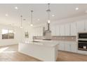 Bright kitchen featuring white cabinets and a large island at 16399 W Avenida Del Sol --, Surprise, AZ 85387