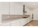 White kitchen with long countertop and stainless steel appliances at 16399 W Avenida Del Sol --, Surprise, AZ 85387