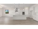 Bright, open kitchen with white cabinetry, an island, and stainless steel appliances at 21726 E Lords Way, Queen Creek, AZ 85142