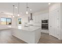 Spacious kitchen with white cabinets, a quartz countertop island, and stainless steel appliances at 21726 E Lords Way, Queen Creek, AZ 85142