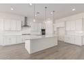 Modern kitchen featuring white shaker cabinets, stainless steel appliances, and a large island at 21726 E Lords Way, Queen Creek, AZ 85142