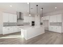 Modern white kitchen with an island, stainless steel appliances, and wood-look flooring at 21673 E Roundup Way, Queen Creek, AZ 85142