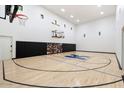 Indoor basketball court with hardwood flooring and two hoops at 4568 S Banning Dr, Gilbert, AZ 85297