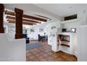 Spacious living room with terracotta tile floors, exposed wooden beams, and built-in shelving at 3968 N Granite Reef Rd, Scottsdale, AZ 85251