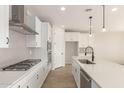 Modern kitchen with white shaker cabinets, quartz counters, stainless steel appliances, and an island at 21665 E Roundup Way, Queen Creek, AZ 85142