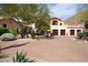 Spanish-style home with a large driveway and mature landscaping at 10728 E Cottontail Ln, Scottsdale, AZ 85255