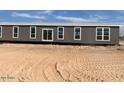 Long single-story home with gray siding at 1653 S 360Th Ave, Tonopah, AZ 85354