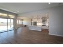 Open concept kitchen and living area with white cabinets, stainless steel appliances, and an island at 5627 N 199Th Dr, Litchfield Park, AZ 85340